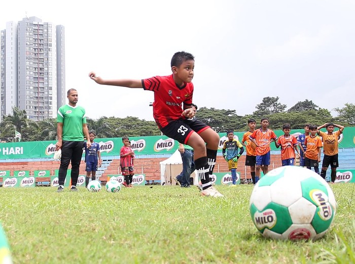 Pesepak bola profesional yang juga penjaga gawang Persija Jakarta Andritany Ardhiyasa (kiri) memberikan pelatihan dasar cara bermain bola yang baik dan benar saat coaching clinic yang menjadi rangkaian babak final MILO National Championship 2026 di Stadion Soemantri Brodjonegoro, Jakarta, Minggu (1/2/2026). Coaching clinic yang diikuti para peserta MILO National Championship 2026, memberikan pelatihan dasar sepak bola, mulai dari passing, ball control, dribbling, hingga aktivitas berbasis permainan dengan melakukan tendangan penalti ke gawang. ANTARA FOTO/Muhammad Iqbal/foc.