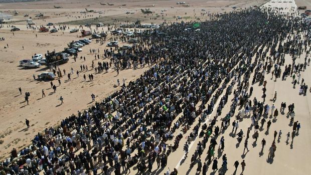 This aerial picture shows Libyans gathered for the funeral of Seif al-Islam Gaddafi, the son of Libya's late longtime ruler, in Bani Walid, in the Tripoli region, western Libya on February 6, 2026. Seif al-Islam, 53, the son of Libya's late longtime ruler, had been seen by some as his father's successor, despite being targeted by a warrant from the International Criminal Court for alleged crimes against humanity. He was killed on February 3, 2026, by gunmen who stormed his home in western Libya's Zintan, his French lawyer told AFP. (Photo by Mahmud Turkia / AFP)
