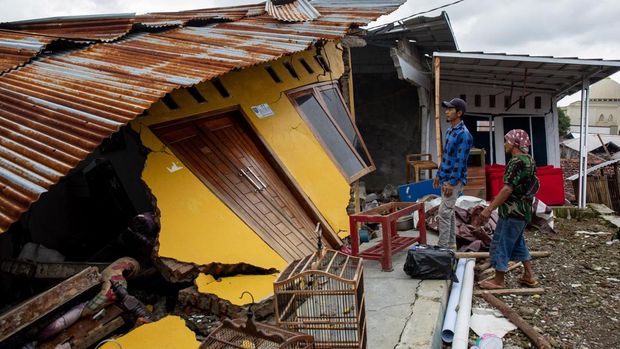 People salvage their belongings after land movement struck Padasari village in Tegal, Central Java, on February 9, 2026, damaging homes, public facilities and schools, leading to the evacuation of thousands of residents. (Photo by DEVI RAHMAN / AFP)