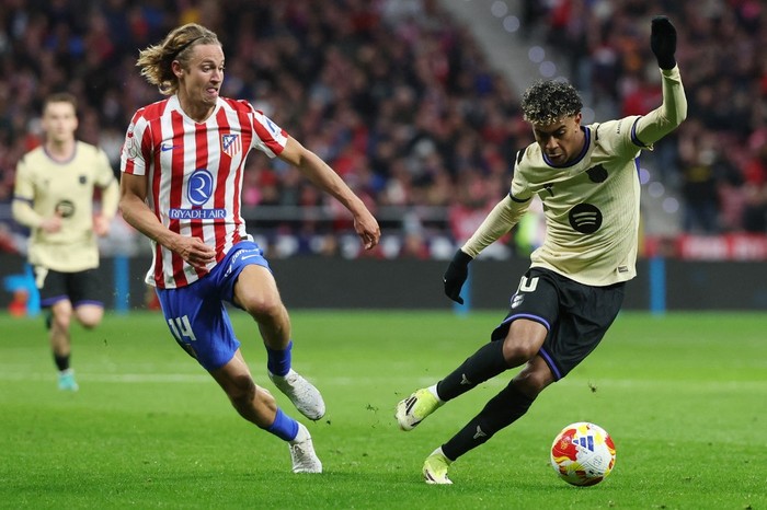 Atletico Madrid's Spanish midfielder #14 Marcos Llorente and Barcelona's Spanish forward #10 Lamine Yamal fight for the ball during the Spanish Copa del Rey (King's Cup) semi final first leg football match between Club Atletico de Madrid and FC Barcelona at Metropolitano Stadium in Madrid on February 12, 2026. (Photo by Pierre-Philippe MARCOU / AFP)