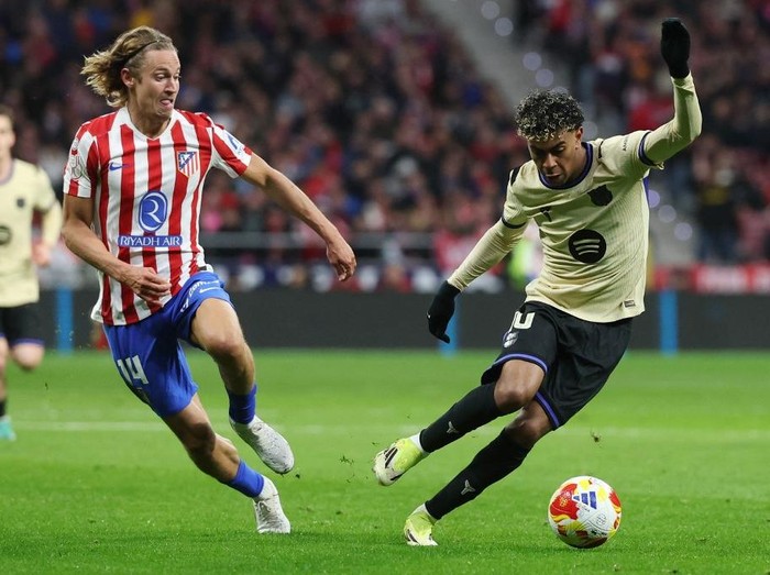 Atletico Madrids Spanish midfielder #14 Marcos Llorente and Barcelonas Spanish forward #10 Lamine Yamal fight for the ball during the Spanish Copa del Rey (Kings Cup) semi final first leg football match between Club Atletico de Madrid and FC Barce