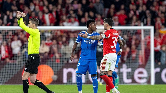 LISBON, PORTUGAL - FEBRUARY 17:  Vinícius Júnior of Real Madrid (L) reacting to racist abuse from fans, Nicolás Otamendi (R) gestures during the UEFA Champions League 2025/26 League Knockout Play-off First Leg match between SL Benfica and Real Mad