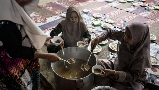 Warga membagikan masakan khas Aceh kuah beulangong dalam tradisi Meugang di dapur darurat Masjid Al-Hidayah, Desa Krueng Lingka, Langkahan, Aceh Utara, Aceh, Selasa (17/2/2026). Masyarakat Krueng Lingka melaksanakan tradisi Meugang secara sederhana melalui kegiatan memotong hewan sapi, memasak, dan makan bersama, serta berbagi daging kepada masyarakat desa setempat yang terdampak bencana hidrometeorologi. ANTARA FOTO/Aprillio Akbar