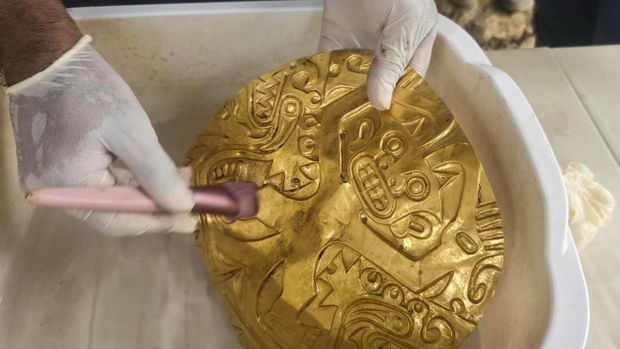 This handout picture released by Panamaís Ministry of Culture shows an archaeologist working inside a pre-Hispanic tomb approximately 1,200 years old, discovered at the El Cano Archaeological Park in Cocle, Panama, on February 20, 2026. The tomb contained the remains of a high-ranking lord of the Cocle culture, along with abundant gold and ceramic grave goods. (Photo by Handout / Panama / AFP)