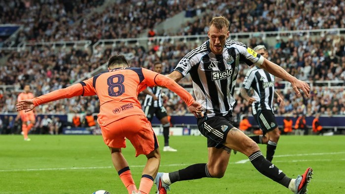 NEWCASTLE UPON TYNE, ENGLAND - SEPTEMBER 18:  Barcelonas Pedri turns with the ball under pressure from Newcastle Uniteds Dan Burn during the UEFA Champions League 2025/26 League Phase MD1 match between Newcastle United FC and FC Barcelona at St Jam