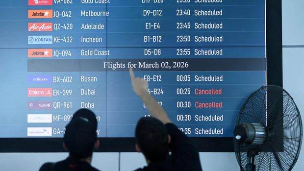 Passengers looks at departure board at I Gusti Ngurah Rai International Airport as some flights to Dubai and Doha cancelled following strikes on Iran launched by the United States and Israel, in Kuta, Bali, Indonesia, March 1, 2026. REUTERS/Johannes Christo