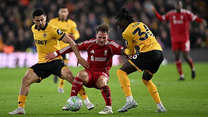 WOLVERHAMPTON, ENGLAND - MARCH 03: (THE SUN OUT, THE SUN ON SUNDAY OUT) Alexis Mac Allister of Liverpool is challenged by Joao Gomes and Mateus Mane of Wolverhampton Wanderers during the Premier League match between Wolverhampton Wanderers and Liverp