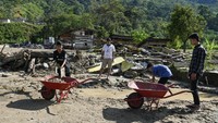 Gotong Royong Warga Bersihkan Sisa Banjir untuk Salat Id