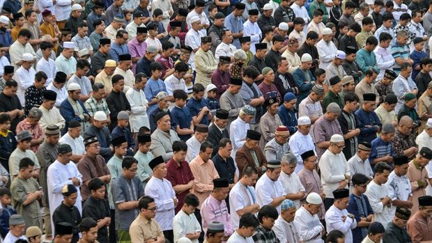 Muslim devotees offer Eid al-Fitr morning prayer along a road in Surabaya on March 20, 2026, marking the end of holy month of Ramadan. (Photo by JUNI KRISWANTO / AFP)
