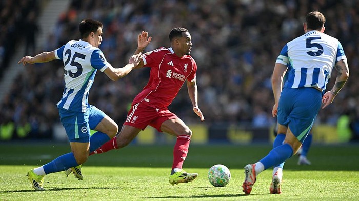 BRIGHTON, ENGLAND - MARCH 21: Ryan Gravenberch of Liverpool is challenged by Diego Gomez and Lewis Dunk of Brighton & Hove Albion during the Premier League match between Brighton & Hove Albion and Liverpool at Amex Stadium on March 21, 2026 in Bright