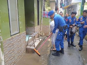 Polairud Polda Metro Bantu Bersihkan Lumpur Sisa Banjir di Kampung Melayu
