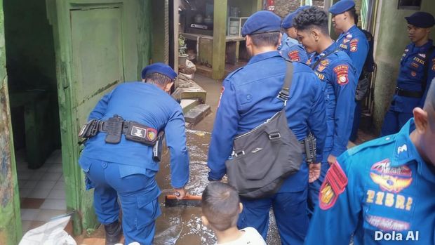 Polairud Polda Metro Jaya membantu bersihkan lumpur sisa banjir di Kampung Melayu