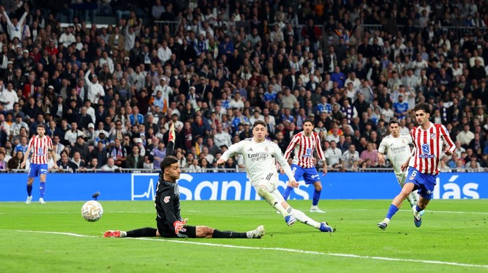 MADRID, SPAIN - MARCH 22: Federico Valverde of Real Madrid scores his teams second goal past Juan Musso of Atletico de Madrid during the LaLiga EA Sports match between Real Madrid CF and Atletico de Madrid at Estadio Santiago Bernabeu on March 22, 2