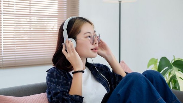 Ilustrasi Perempuan Bekerja dengan Mendengarkan Musik/Foto: Freepik.com/studioredcup