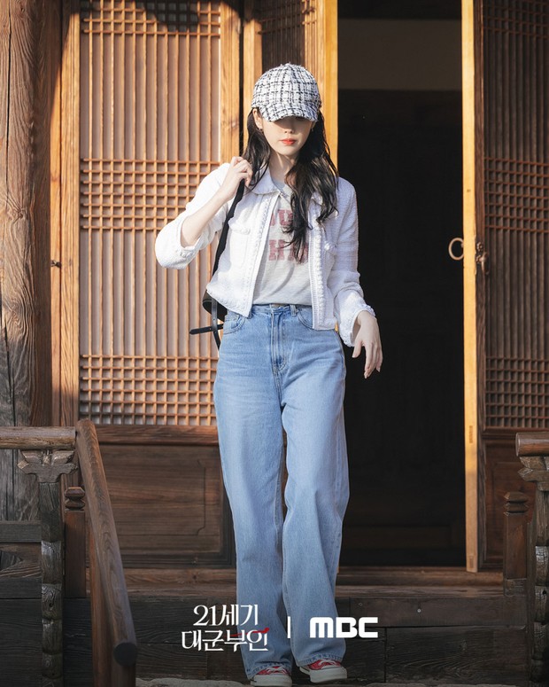 IU menambahkan sentuhan warna dengan sepatu kets merah pada pakaian kasual jeans-nya