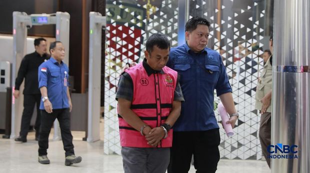 Tersangka kasus korupsi tata kelola minyak mentah melangkah menuju mobil tahanan di gedung Kejaksaan Agung, Jakarta, Kamis (9/4/2026) malam. (CNBC Indonesia/Muhammad Sabki)