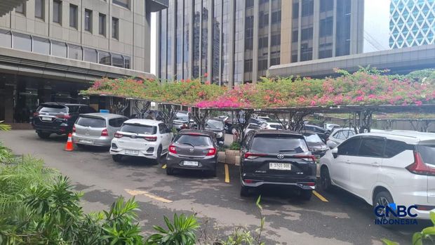 Sejumlah kendaraan tetap memenuhi area parkir di instansi Kementerian Perumahan dan Kawasan Permukiman di Jakarta, Jumat (10/4/2026), seiring penerapan kebijakan work from home (WFH) bagi ASN dan imbauan serupa bagi sektor swasta. (CNBC Indonesia/Ferry Sandi)