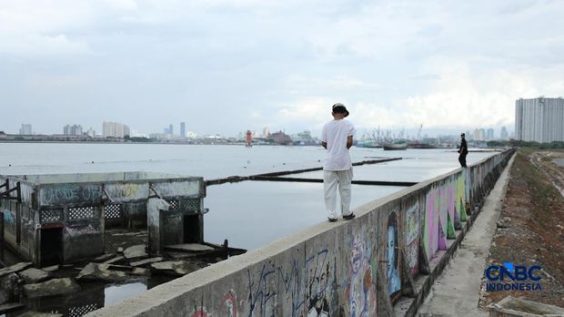 Sejumlah penduduk beraktivitas di area tanggul Pantai Muara Baru, Jakarta, Jumat (10/4/2026). (CNBC Indonesia/Tri Susilo)