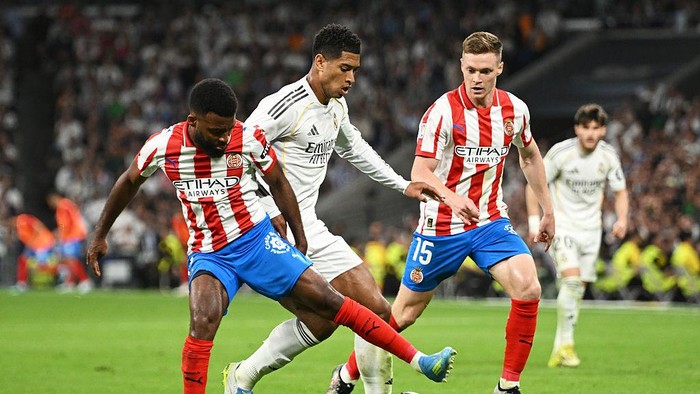 MADRID, SPAIN - APRIL 10: Jude Bellingham of Real Madrid is challenged by Thomas Lemar of Girona FC during the LaLiga EA Sports match between Real Madrid CF and Girona FC at Estadio Santiago Bernabeu on April 10, 2026 in Madrid, Spain. (Photo by Deni