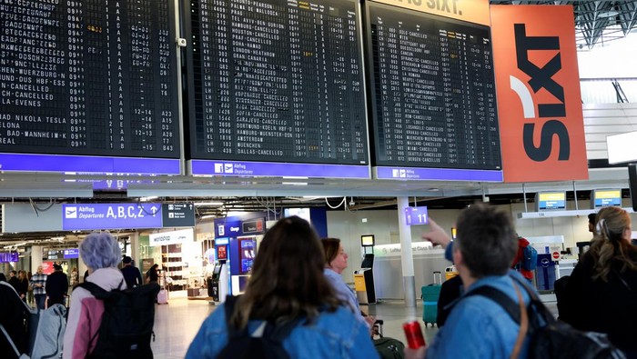 Protes Kondisi Kerja, Awak Kabin Mogok Massal A person points at an information panel that shows flights, many of which are cancelled, during a strike by the UFO union, representing Lufthansa cabin crew, at Frankfurt Airport, Germany, April 10, 2026. REUTERS/Heiko Becker