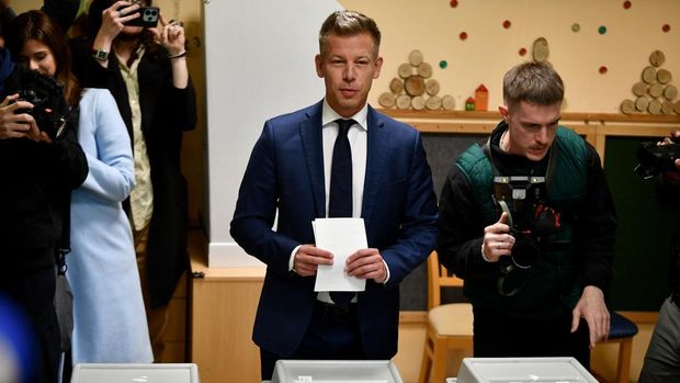 Peter Magyar (C), leader of the pro-European conservative TISZA party, prepares to cast his ballot at a polling station set up in a kindergarten in Budapest during a general election in Hungary, on April 12, 2026. The vote could end Hungarian Prime Minister Viktor Orban's 16-year stint in power as the EU's longest serving current leader and a self-decribed 
