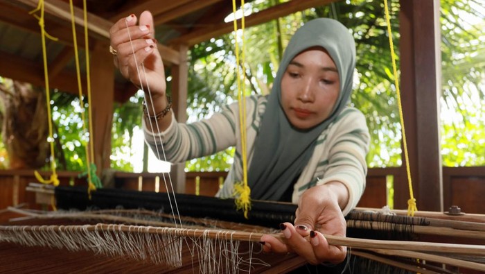 Dari Aceh ke Prancis, Songket Tradisional Tembus Pasar Internasional Ira Mutiara (33), pemilik rumah produksi Mutiara Songket, memperlihatkan kain songket unik Aceh di Aceh Besar, Aceh, Selasa (14/4/2026). Rumah produksi tersebut bisa memproduksi kain songket unik Aceh sebanyak 10 helai per bulan dengan beragam motif seperti Pintu Aceh, Bunga Lawang, dan Bunga Jeumpa nan dipasarkan ke beragam wilayah seperti Sumatera Utara, Sumatera Barat, Sulawesi, dan Jakarta dengan nilai jual berkisar Rp800 ribu-Rp3 juta per helai serta turut dipamerkan pada arena fesyen internasional di Prancis. ANTARA FOTO/Akramul Muslim