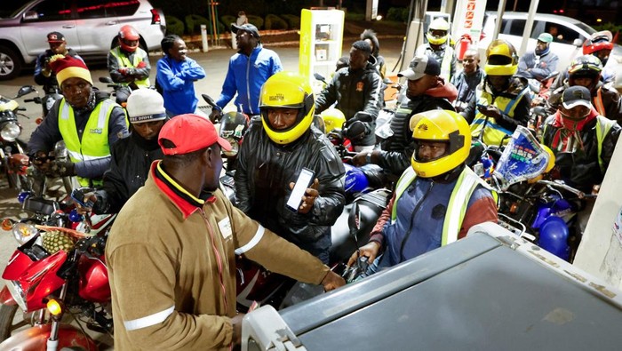 A motorcycle taxi rider gestures to the camera as he calls for more fuel to be readily available while waiting to refuel his motorcycle at a TotalEnergies petrol station ahead of an announced fuel price hike, as fuel costs rise amid dunia disruptions caused by the Iran war, in Nairobi, Kenya April 14, 2026. REUTERS/Thomas Mukoya