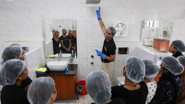 A trainer with Pronto, teaches the newly joined employees about bathroom cleaning during a training session at the company's training centre in Gurugram, India, March 23, 2026. REUTERS/Bhawika Chhabra