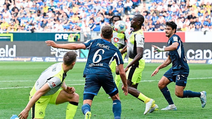 18 April 2026, Baden-Württemberg, Sinsheim: Soccer, Men: Bundesliga, TSG 1899 Hoffenheim - Borussia Dortmund, Matchday 30, PreZero Arena. Serhou Guirassy (2nd from right, Borussia Dortmund) and Ozan Kabak (right, 1899 Hoffenheim) fight for the ball.