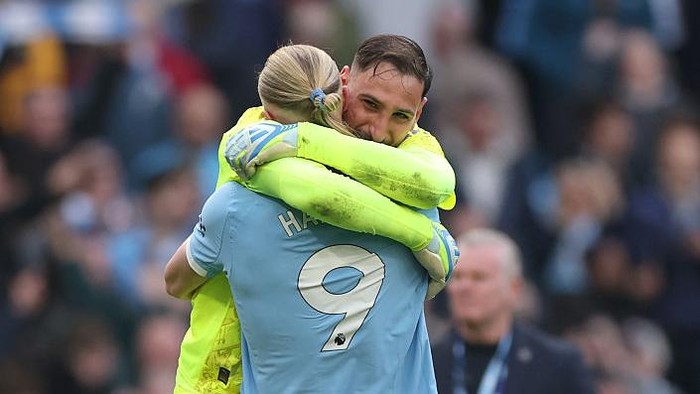 Gianluigi Donnarumma (menghadap kamera) memeluk Erling Haaland usai Manchester City mengalahkan Arsenal 2-1.