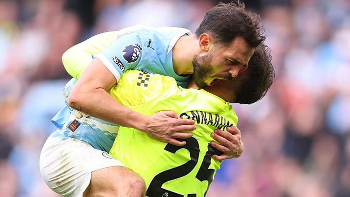 Bernardo Silva (kiri) merayakan kemenangan Manchester City atas Arsenal dengan memeluk Gianluigi Donnarumma.