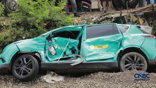 Kereta Krl melintas disamping taksi Green SM nan tertabrak KRL di perlintasan kereta Jalan Ampera, Bekasi, Selasa (28/4/2026). (CNBC Indonesia/Muhammad Sabki)