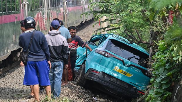 Warga mengawasi taksi listrik Green SM nan rusak pascakecelakaan dengan KRL Commuter Line dan KA Argo Bromo Anggrek di Bekasi Timur, Bekasi, Jawa Barat, Selasa (28/4/2026). Komite Nasional Keselamatan Transportasi (KNKT) mengerahkan tim investigasi untuk mengumpulkan kebenaran mengenai kecelakaan kereta api di Stasiun Bekasi Timur pada Senin (27/4) malam. ANTARA FOTO/Fakhri Hermansyah/nz