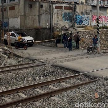 Perlintasan letak taksi tertemper KRL di Bekasi Timur hanya ditutup palang bambu. Perlintasan tak resmi tersebut dijaga penduduk secara bergantian. (Isal M/detikcom)