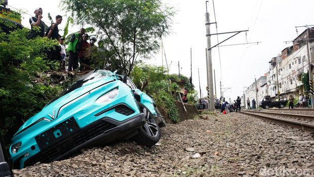Sebuah taksi berwarna hijau terlihat rusak parah di letak kecelakaan kereta. Insiden tersebut terjadi di Stasiun Bekasi Timur, Jawa Barat, Selalsa (28/4/2026).