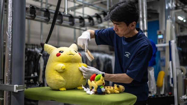 In this picture taken on April 27, 2026, dry-cleaning professional Masakazu Shimura brushes a soft toy at the facility of Cleaning Yonmarusan in Fuefuki city of Yamanashi Prefecture. A worn-out Pikachu plushie, tired teddy bear or stained stuffed animal can all get a new lease on life at a Japanese laundry service making beloved toys squeaky clean again. (Photo by Philip FONG / AFP) / TO GO WITH AFP STORY: Japan-culture-toys-internet, by Hiroshi Hiyama