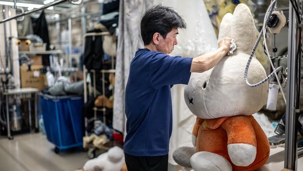 In this picture taken on April 27, 2026, dry-cleaning professional Masakazu Shimura cleans a soft toy at the facility of Cleaning Yonmarusan in Fuefuki city of Yamanashi Prefecture. A worn-out Pikachu plushie, tired teddy bear or stained stuffed animal can all get a new lease on life at a Japanese laundry service making beloved toys squeaky clean again. (Photo by Philip FONG / AFP) / TO GO WITH AFP STORY: Japan-culture-toys-internet, by Hiroshi Hiyama