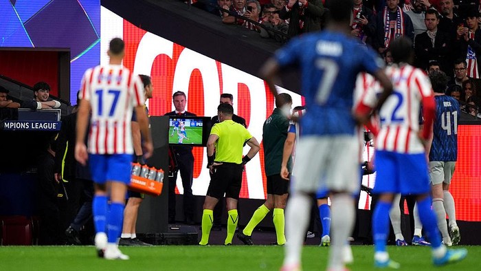 MADRID, SPAIN - APRIL 29: Referee Danny Makkelie checks the VAR screen before overturning a penalty to Arsenal for a foul by David Hancko of Atletico de Madrid (not pictured) on Eberechi Eze of Arsenal (not pictured) during the UEFA Champions League 