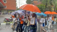 Potret Buruh di Surabaya Tetap Long March Meski Diguyur Hujan
