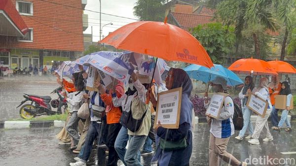 Potret Buruh di Surabaya Tetap Long March Meski Diguyur Hujan