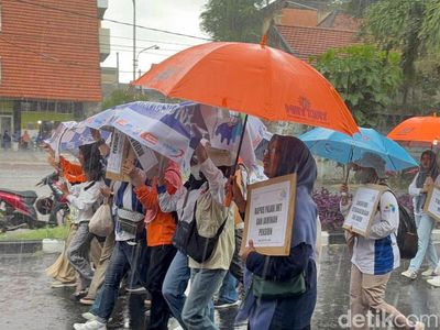 Potret Buruh di Surabaya Tetap Long March Meski Diguyur Hujan