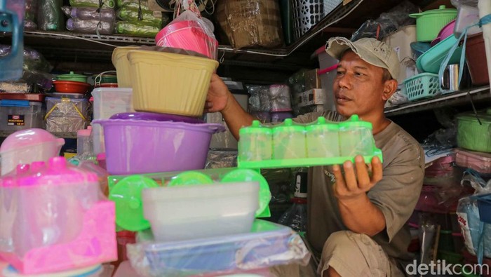 Pedagang menata gelas cerah plastik di salah satu toko peralatan rumah tangga di area Pasar Jatinegara, Bali Mester, Jakarta Timur. Sejumlah perabot rumah tangga berbahan plastik, alumunium hingga melamin mengalami kenaikan nilai dalam beberapa bulan terakhir akibat melonjaknya biaya bahan baku dan distribusi.