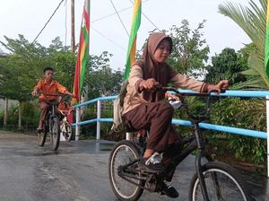 Senyum Anak-anak Sekolah di Jembatan Merah Putih Pelalawan