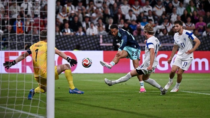 Germanys midfielder #23 Felix Nmecha (2L) makes an attempt on goal against Finlands goalkeeper #01 Lucas Hradecky (L) during a friendly match between Germany and Finland ahead of the 2026 FIFA World Cup football tournament, in Mainz, western German