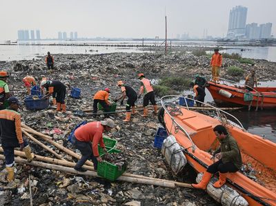 Petugas Bersihkan Hamparan Sampah di Perairan Jakarta