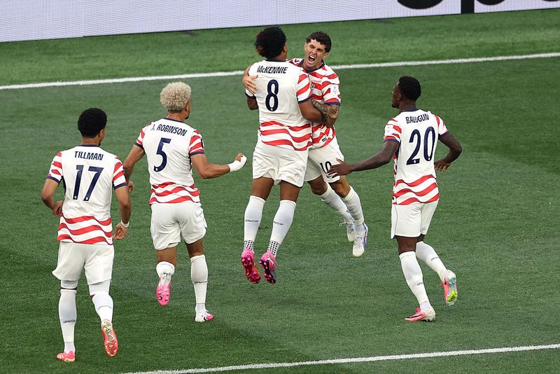 LOS ANGELES, CALIFORNIA - JUNE 12: Christian Pulisic #10 and Weston McKennie #8 of the United States celebrate their side's first goal, an own goal by Damian Bobadilla #16 of Paraguay (not pictured), during the FIFA World Cup 2026 Group D match between USA and Paraguay at Los Angeles Stadium on June 12, 2026 in Los Angeles, California. (Photo by Matt McNulty - FIFA/FIFA via Getty Images)