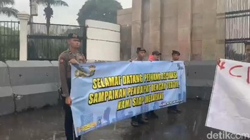 Momen Polisi Kawal Demonstrasi di Gedung DPR di Tengah Hujan