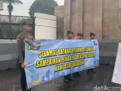 Momen Polisi Kawal Demonstrasi di Gedung DPR di Tengah Hujan