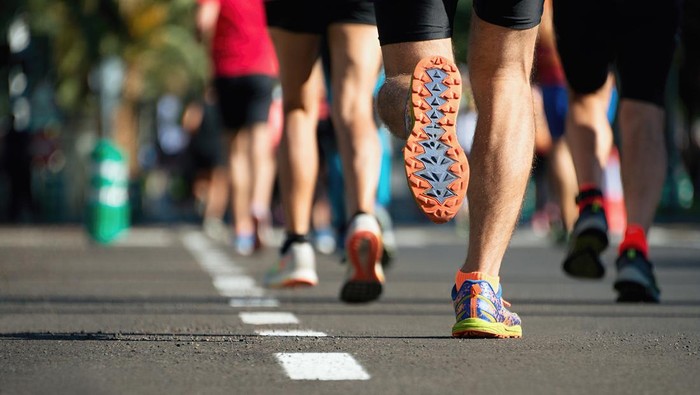 Lomba lari maraton, kaki orang-orang di jalan kota.