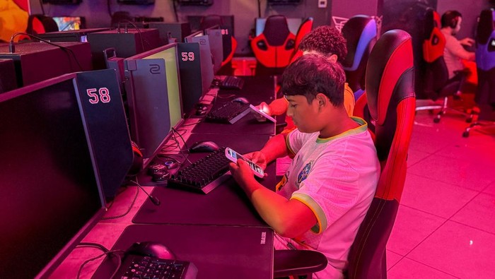 Anak-anak melihat telepon genggam di pusat permainan Dubai